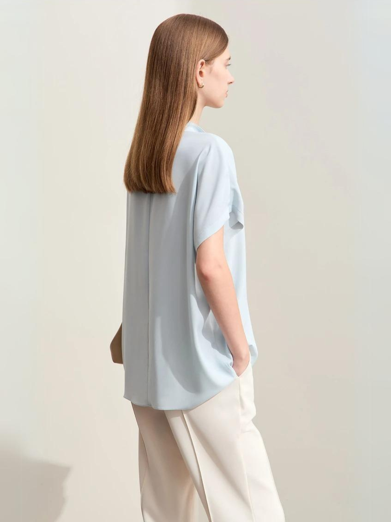 Back view of light blue blouse with relaxed fit and short sleeves