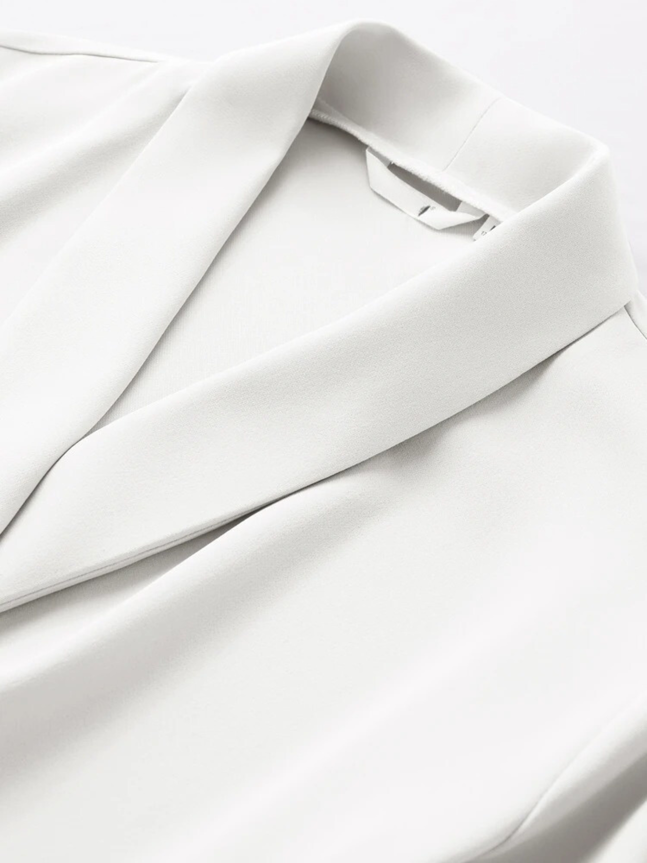 Close-up of collar and shoulder detail on white blouse