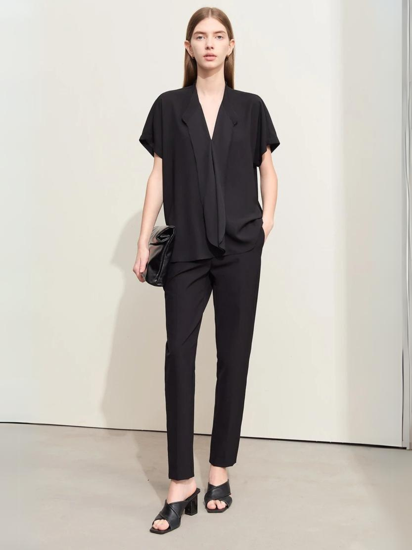 Full-body view of black blouse with V-neck and tailored black pants