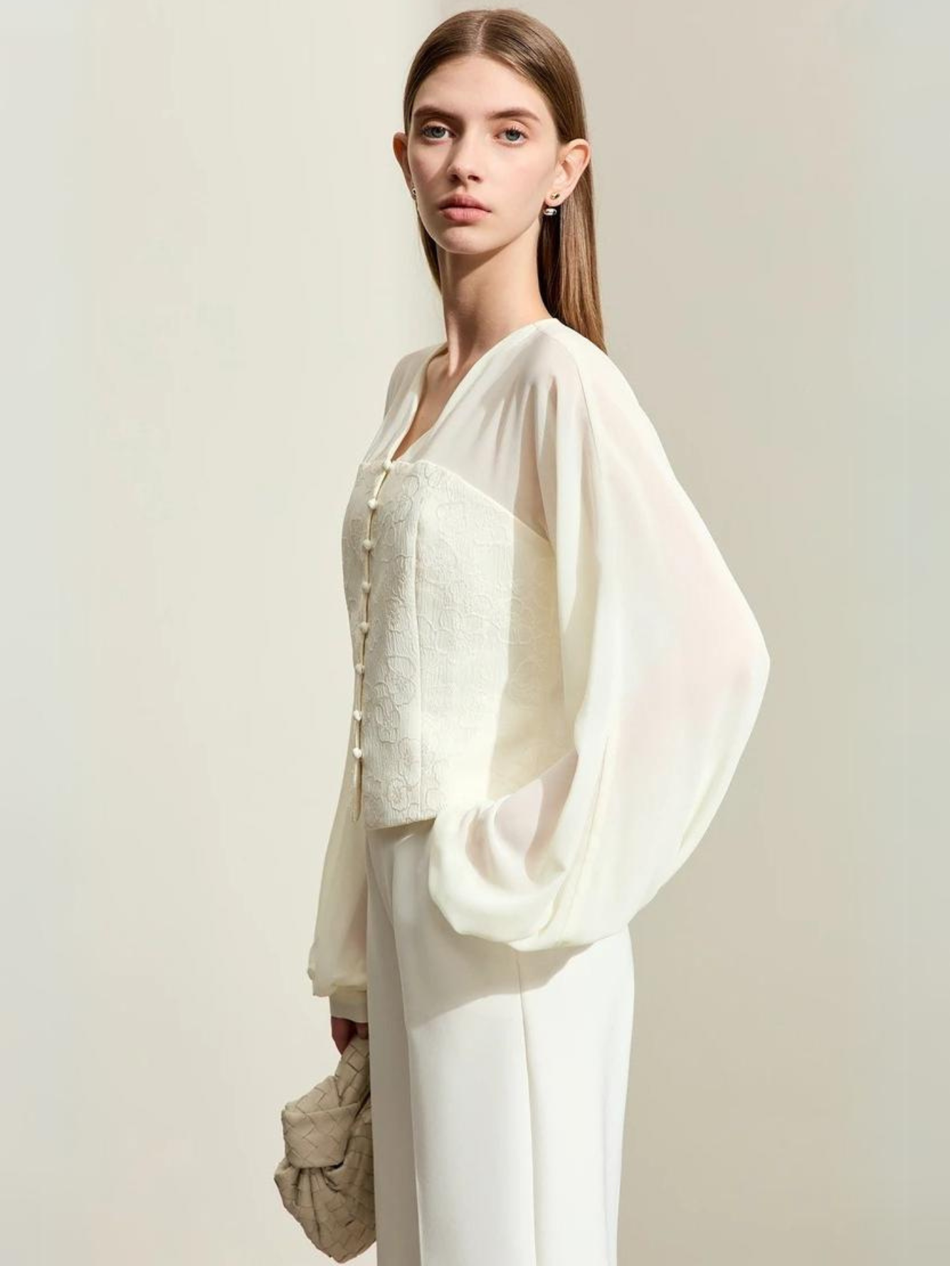 Side view of cream blouse with embroidered vest detail