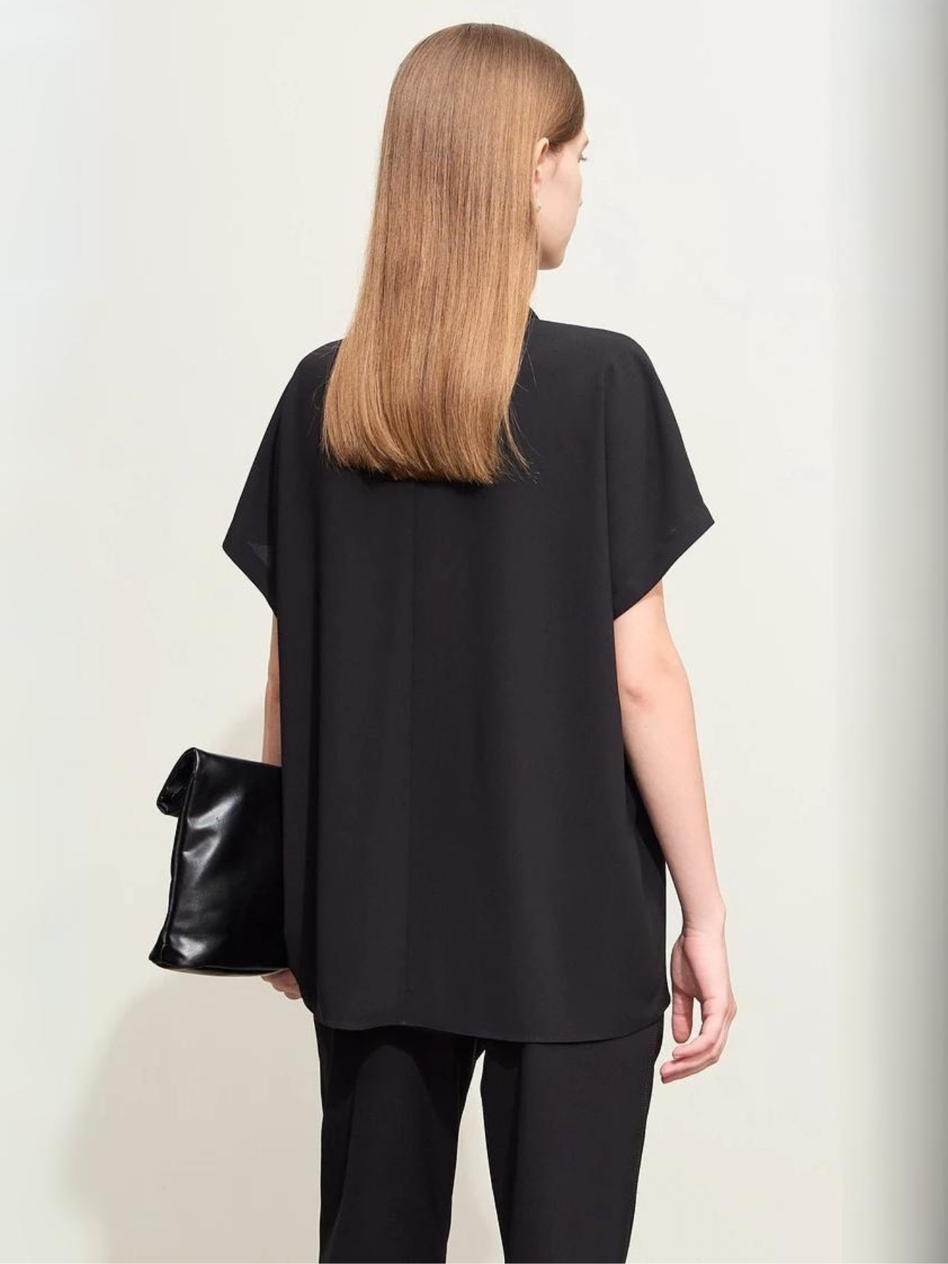 Side view of woman wearing black blouse with short sleeves