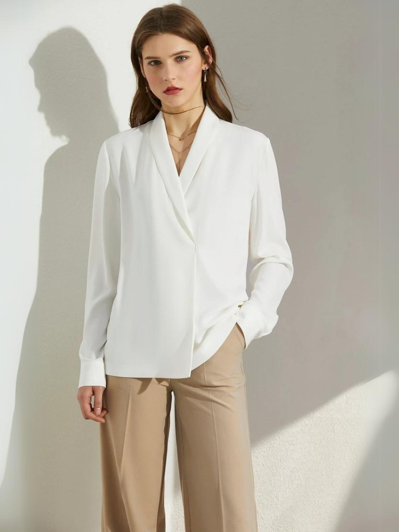 Side profile of woman in white blouse with relaxed fit