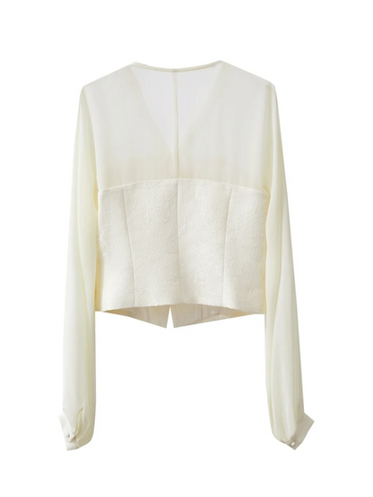Back view of cream blouse laid flat