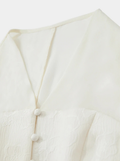 Close-up of front buttons and neckline on cream blouse