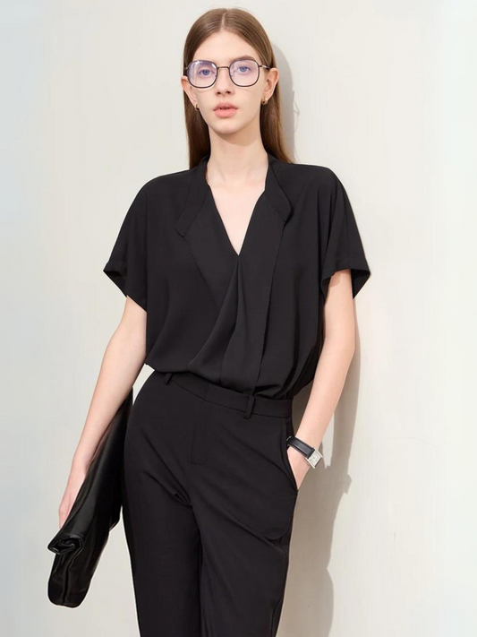 Woman in black draped short-sleeve blouse with matching trousers