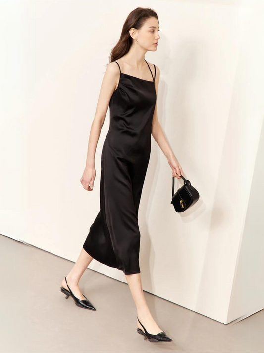 Woman in black satin slip dress with spaghetti straps walking