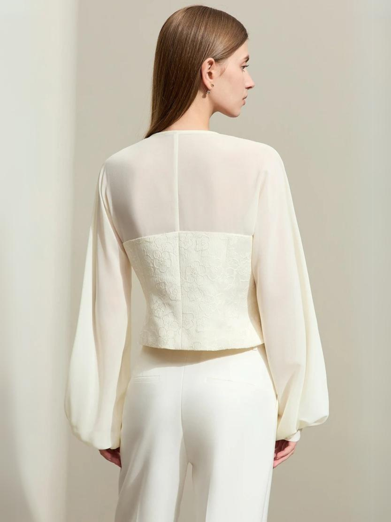 Full-body view of cream blouse with sheer back