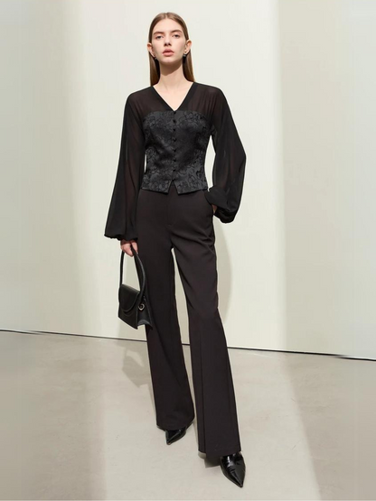 Black blouse with V-neck and wrapped look, arms crossed