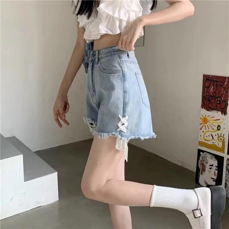 Dame denimshorts med trendy ødelagte detaljer og håndlagde høydepunkter