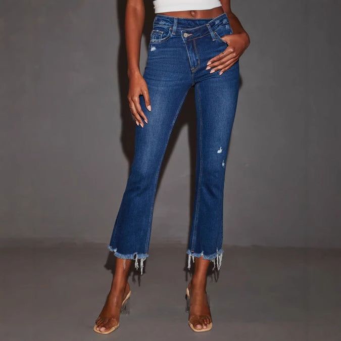 Kvinnelige utsvingte jeans med trendy ødelagte detaljer og frynsete kanter