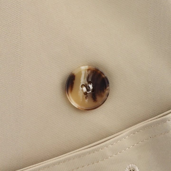 Dame moderiktig trenchcoat med asymmetrisk knappestolpe og belte i midjen Skjora