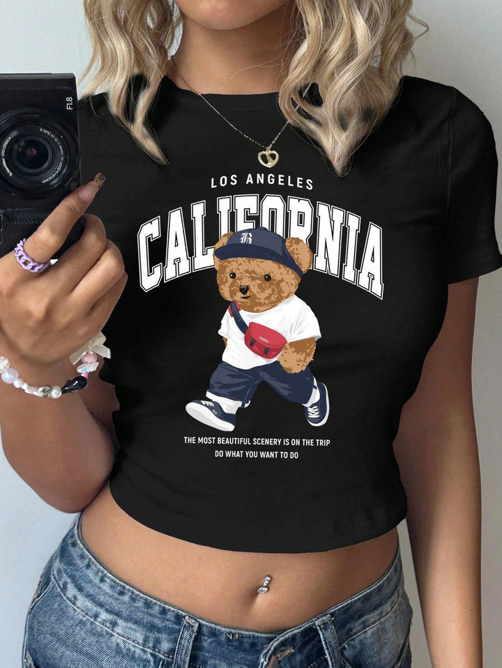 Dame Crop-T-shirt med lekent bjørnemotiv og moderne skrift Skjora