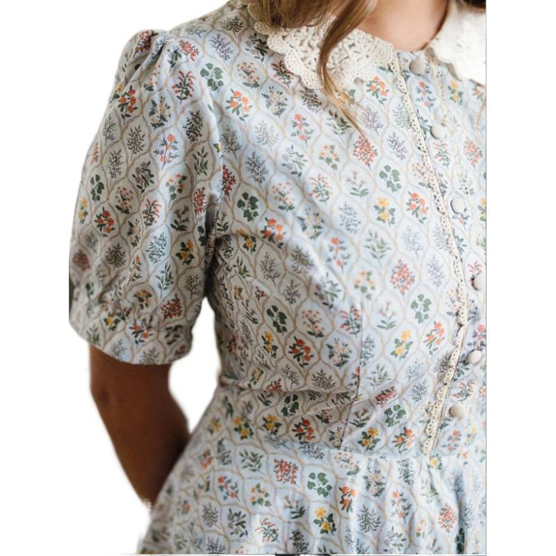 Damekjole med romantisk blomsterdesign og elegant krage Skjora