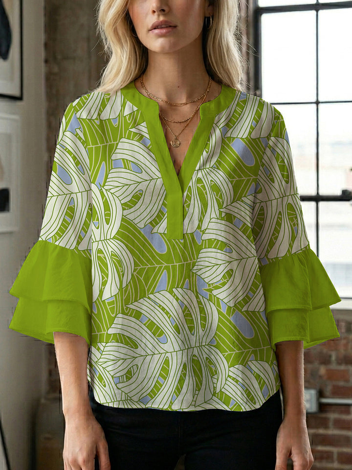 Damebluse med voluminøse volangermer og floral trykk Skjora