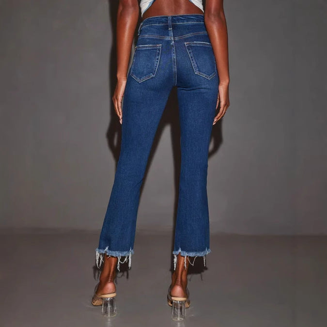 Kvinnelige utsvingte jeans med trendy ødelagte detaljer og frynsete kanter