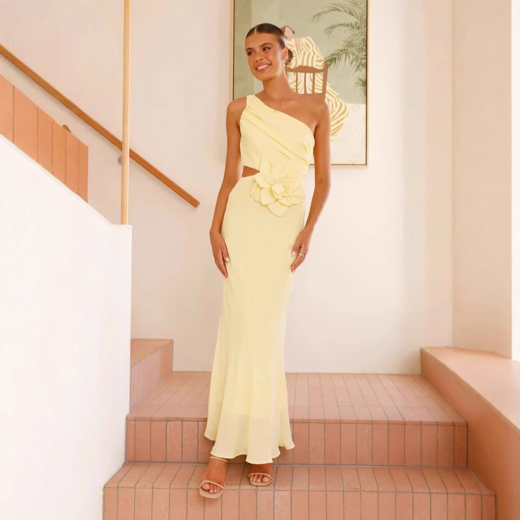 Kvinnens elegante maxikjole med asymmetrisk snitt og blomsterdetalj