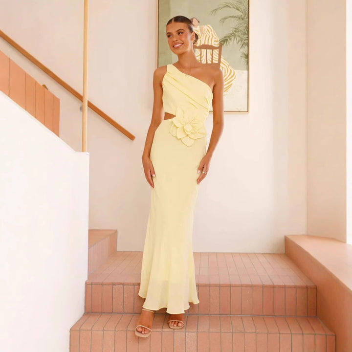 Kvinnens elegante maxikjole med asymmetrisk snitt og blomsterdetalj