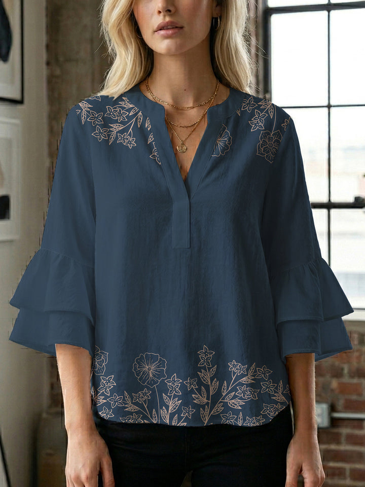 Damebluse med voluminøse volangermer og floral trykk Skjora