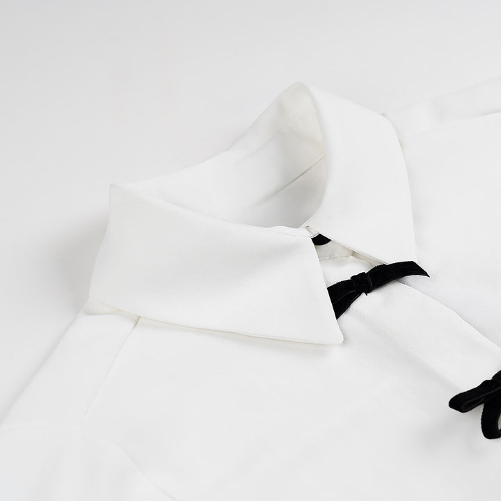 Kvinnens klassiske bluse med dekorative knuter og elegante detaljer Skjora