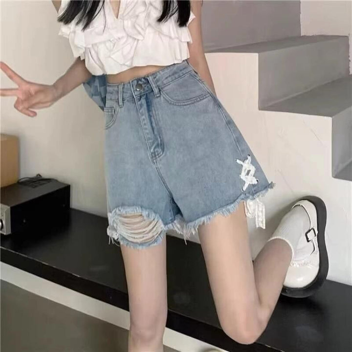 Dame denimshorts med trendy ødelagte detaljer og håndlagde høydepunkter