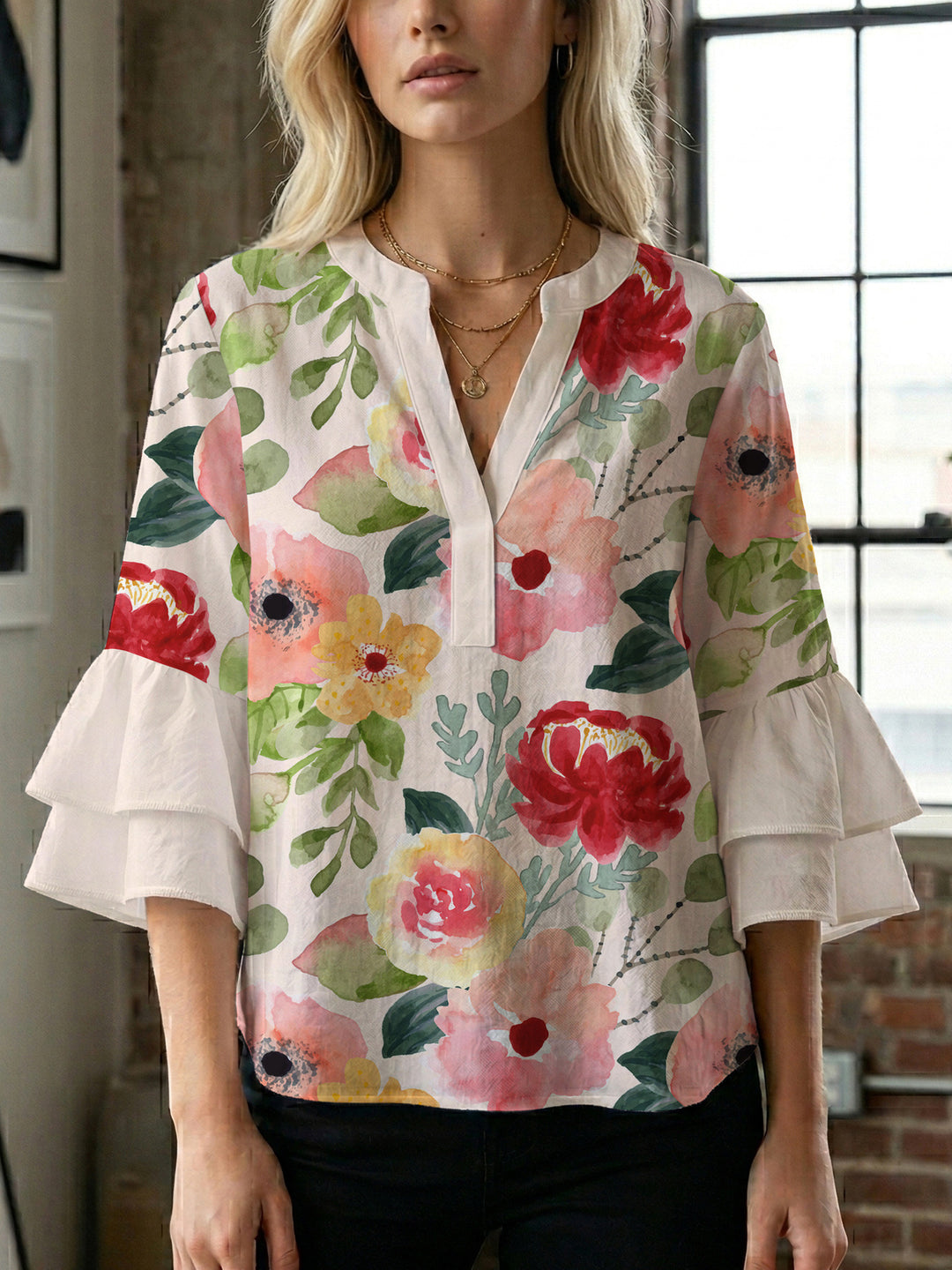 Damebluse med voluminøse volangermer og floral trykk Skjora