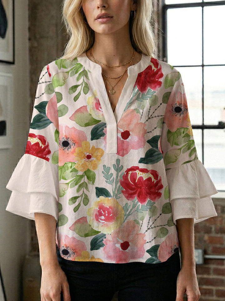 Damebluse med voluminøse volangermer og floral trykk Skjora