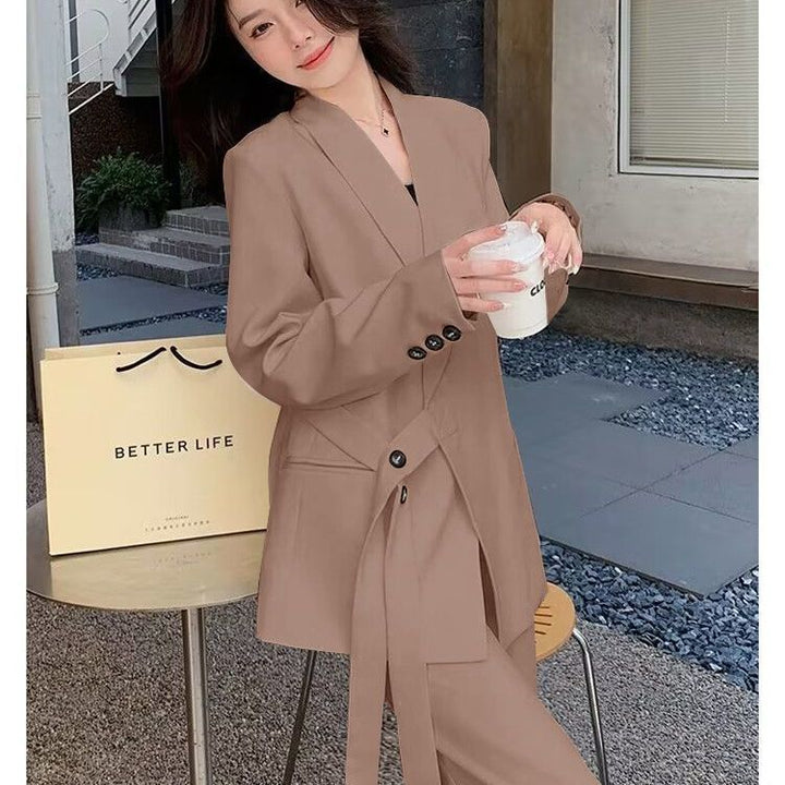 Kvinnens moderne blazer med asymmetrisk snitt og midjebelte Skjora