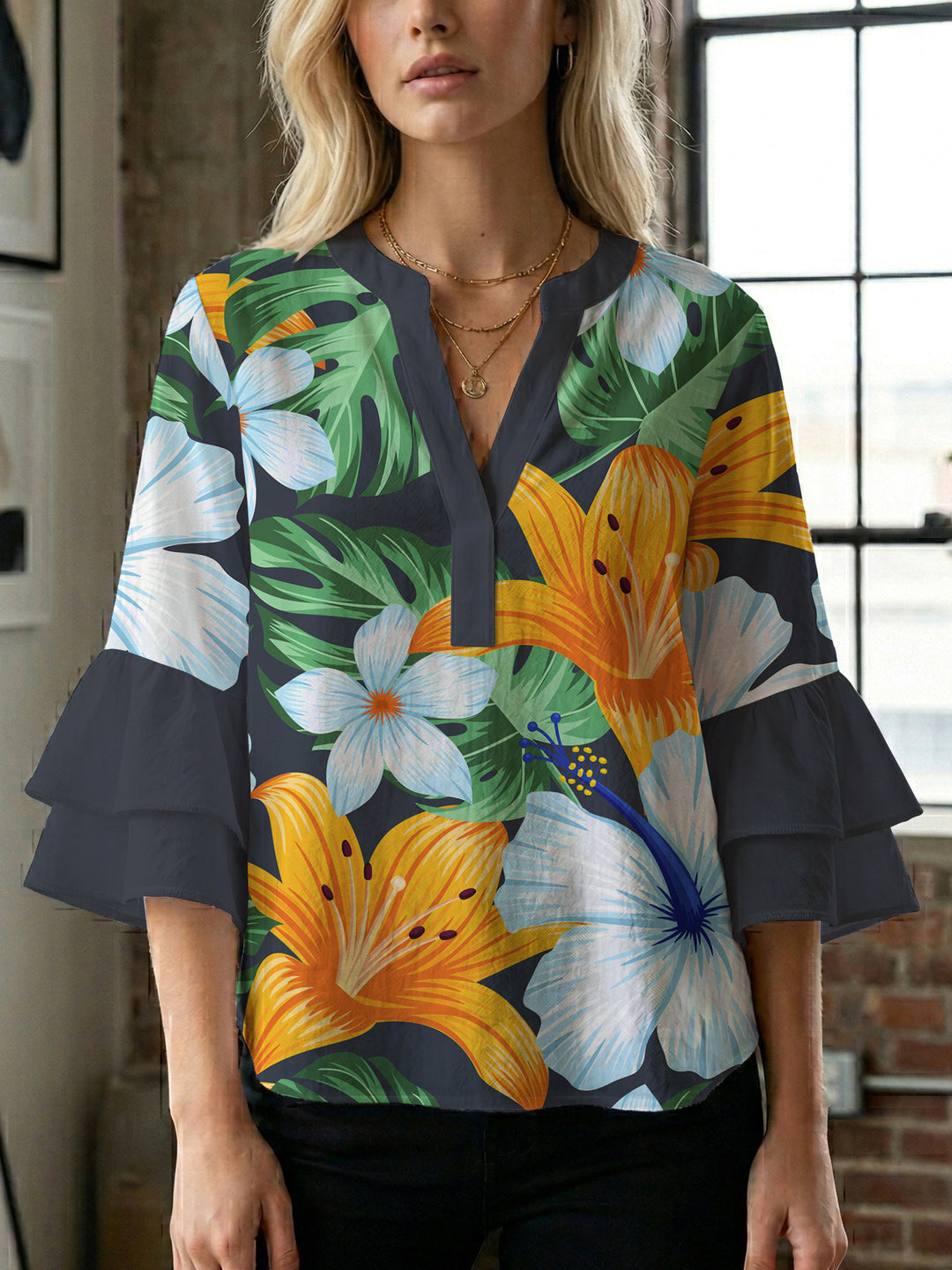 Damebluse med voluminøse volangermer og floral trykk Skjora