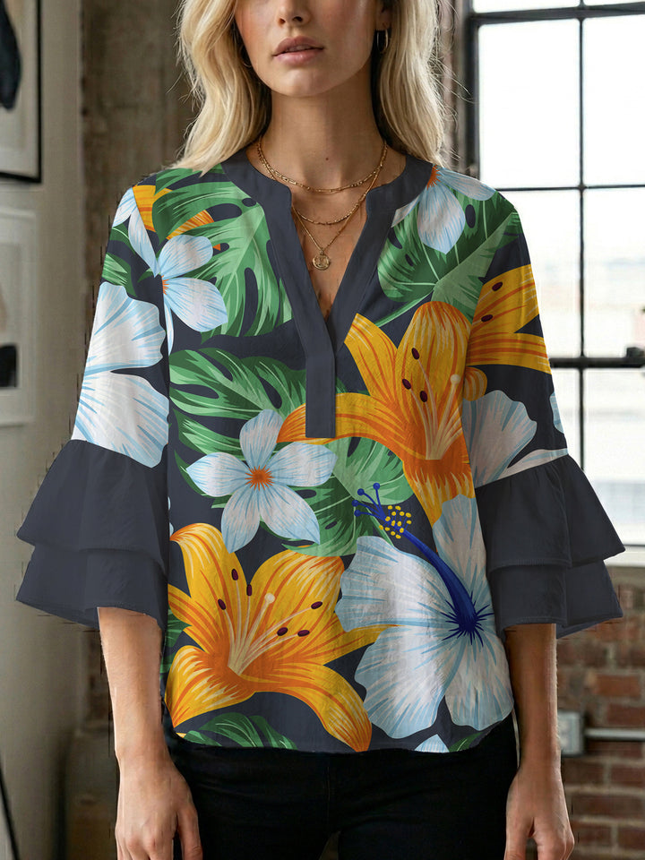 Damebluse med voluminøse volangermer og floral trykk Skjora