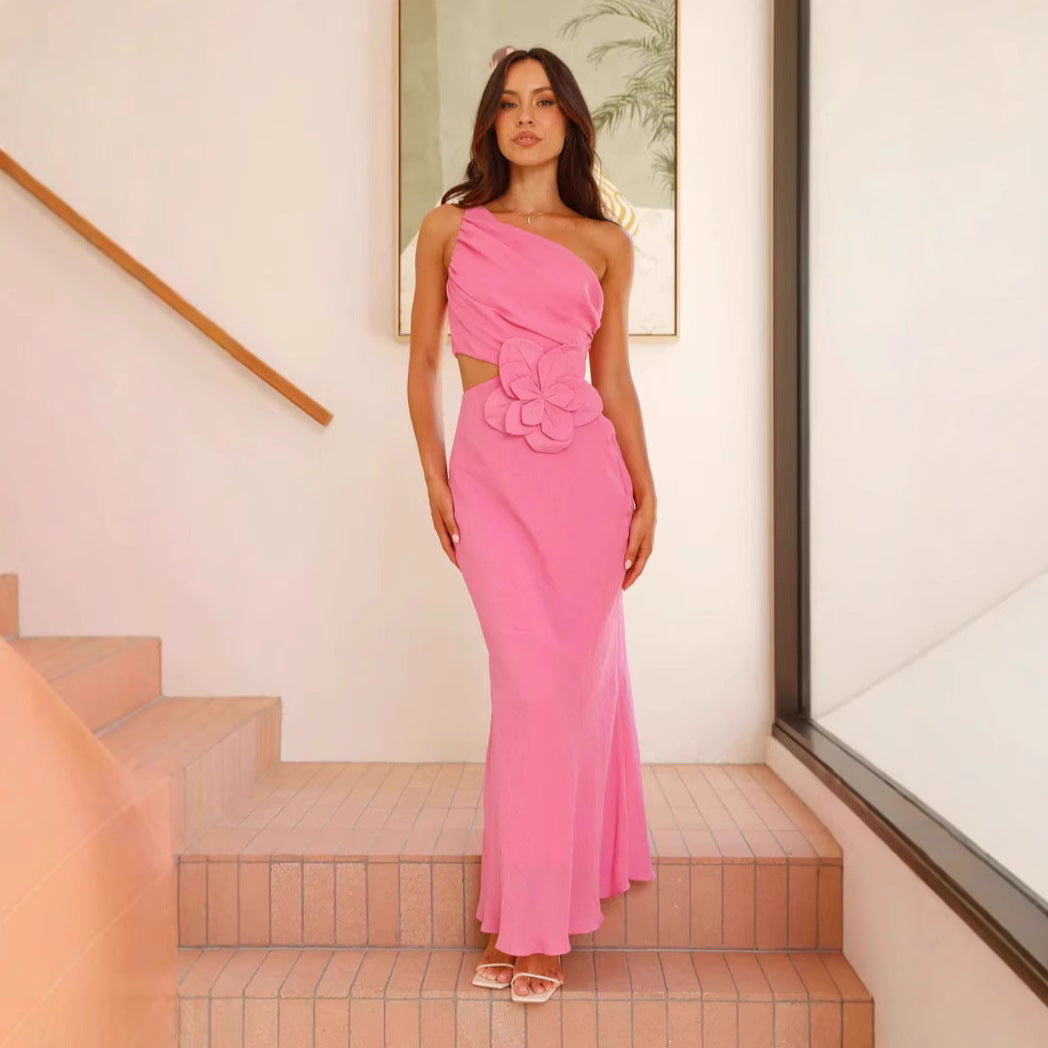 Kvinnens elegante maxikjole med asymmetrisk snitt og blomsterdetalj
