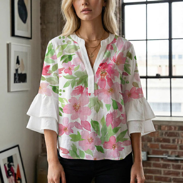 Damebluse med voluminøse volangermer og floral trykk Skjora