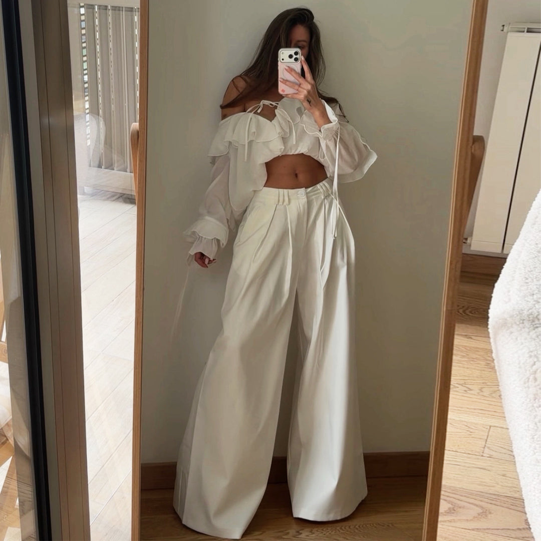 Damebluse med voluminøse volangdetaljer og kapteinsærmer