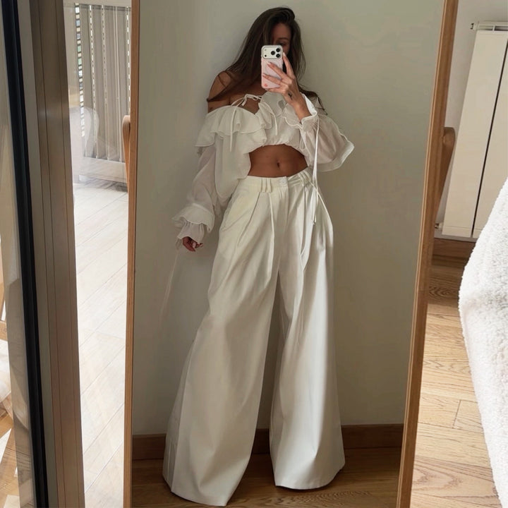 Damebluse med voluminøse volangdetaljer og kapteinsærmer