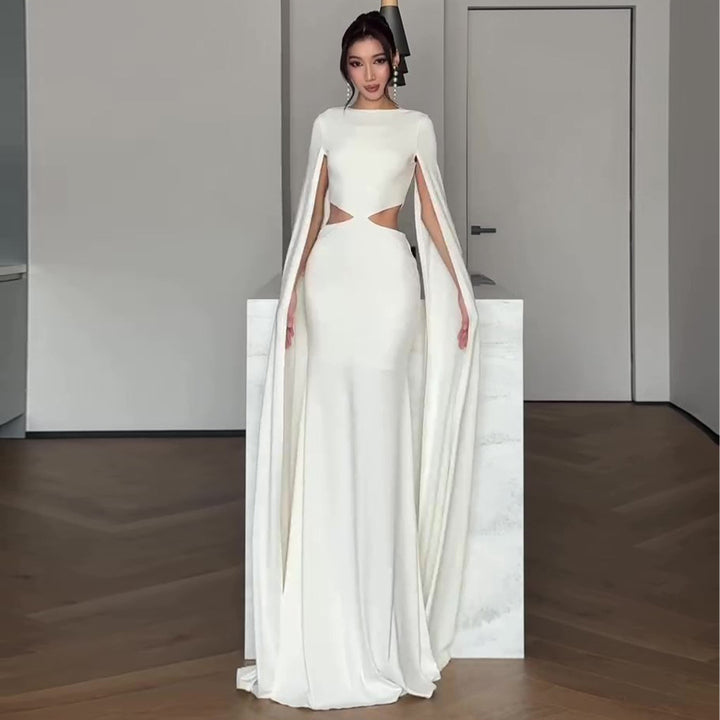 Kvinnens elegante kveldskjole med innovativt cut-out og dramatisk kappe
