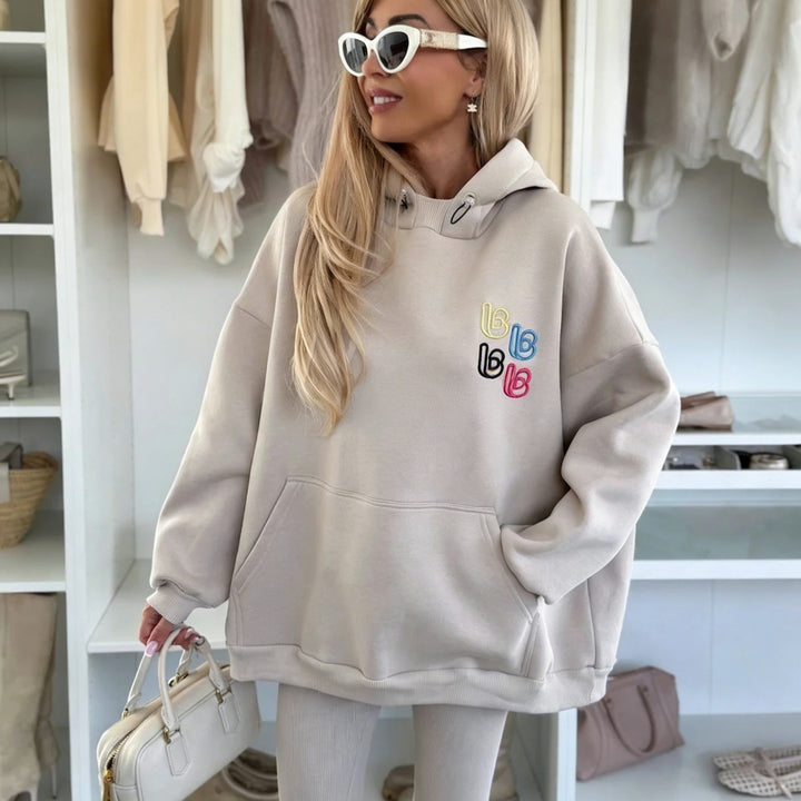 Kvinnens avslappede oversized hettegenser med fargerik logo og kengurulomme Skjora