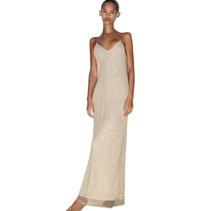 Kvinnens elegante maxi-kjole med intrikate mesh-detaljer og tynne spaghetti-stropper