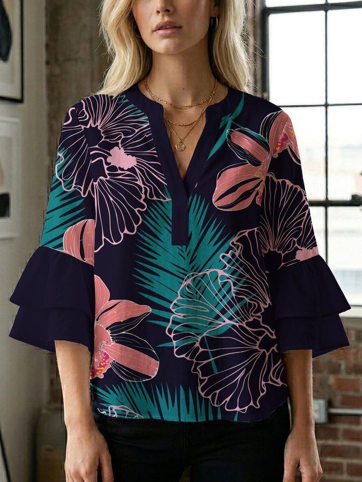 Damebluse med voluminøse volangermer og floral trykk Skjora