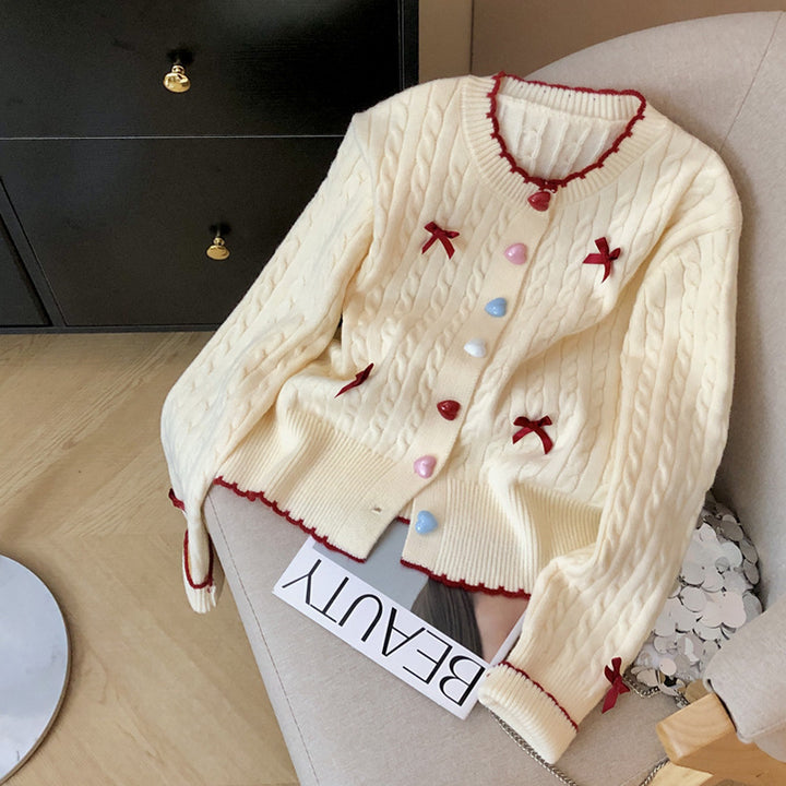 Kvinnens chunky strikket cardigan med lekne knappdetaljer og sløyfer
