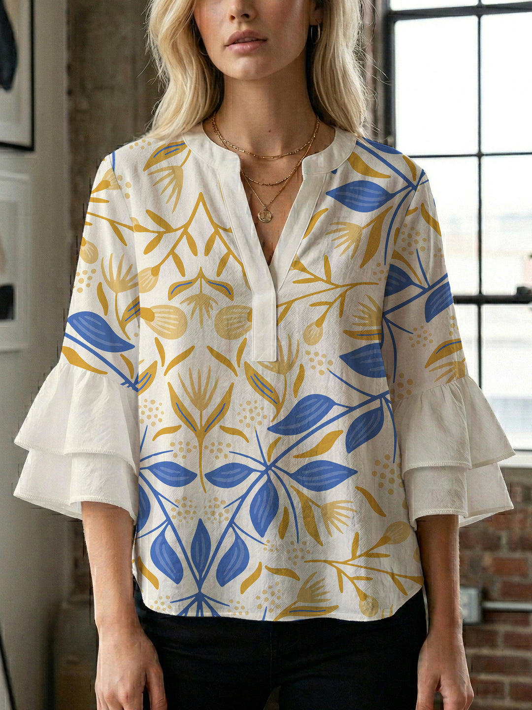 Damebluse med voluminøse volangermer og floral trykk Skjora