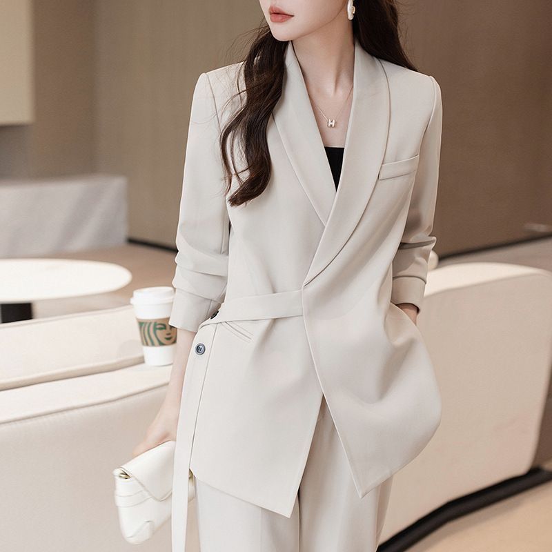 Kvinnens moderne blazer med asymmetrisk snitt og midjebelte Skjora