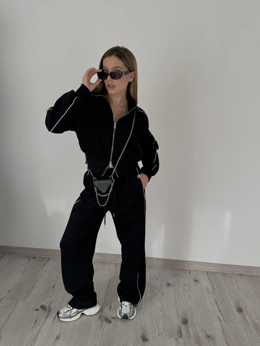 Kvinnelig trendy joggedress med stilige glidelåser og kontrasterende sømmer