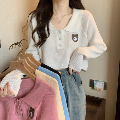 Kvinne cropped genser med en knapp lukking og unicorn emblem