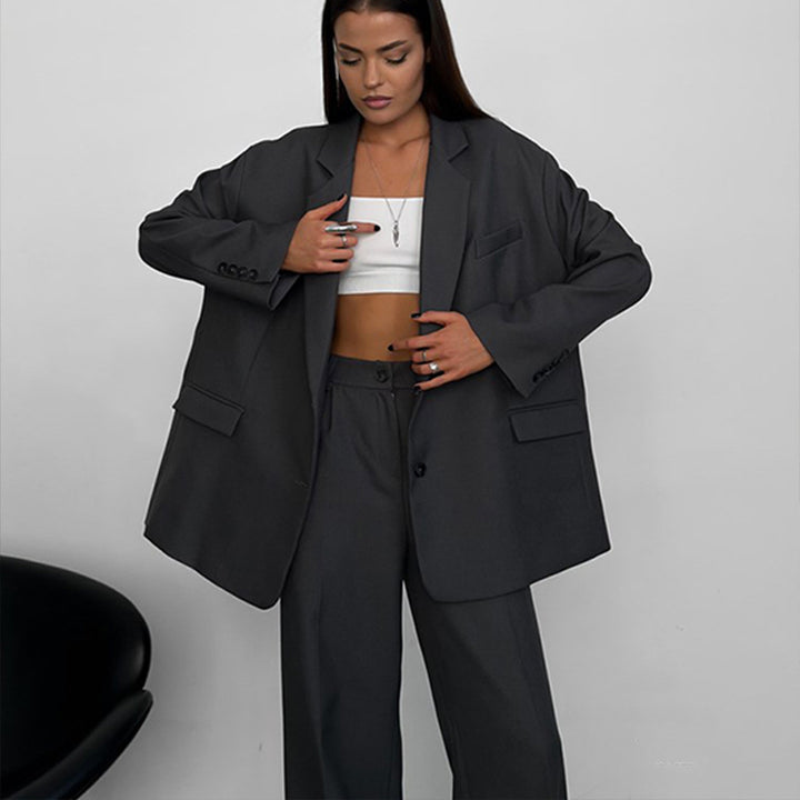 Kvinnelig elegant to-dels sett med oversized blazer og vide bukser Skjora