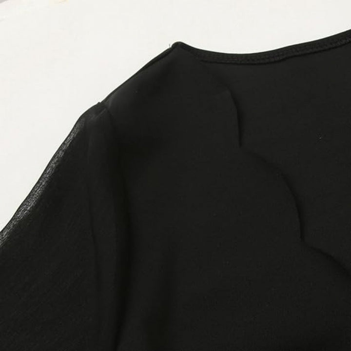 Elegant kjole for kvinner med gjennomsiktige ermer og V-hals Skjora