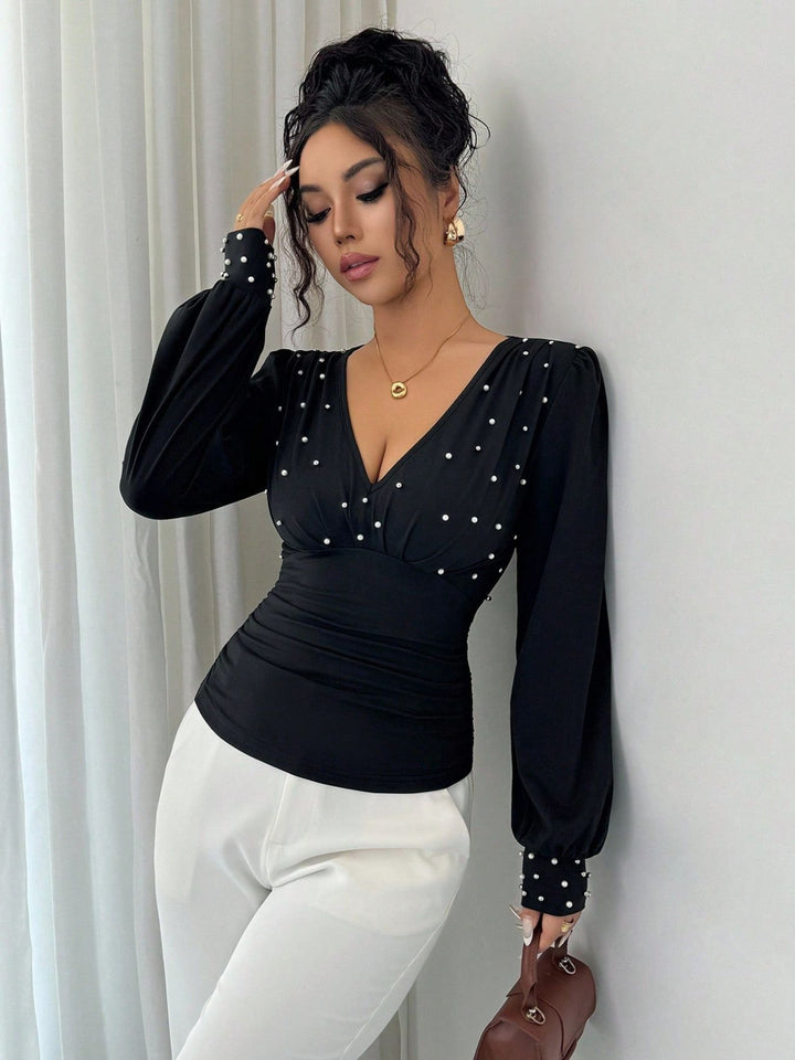 Kvinnes elegant bluse med V-hals og dekorasjon Skjora