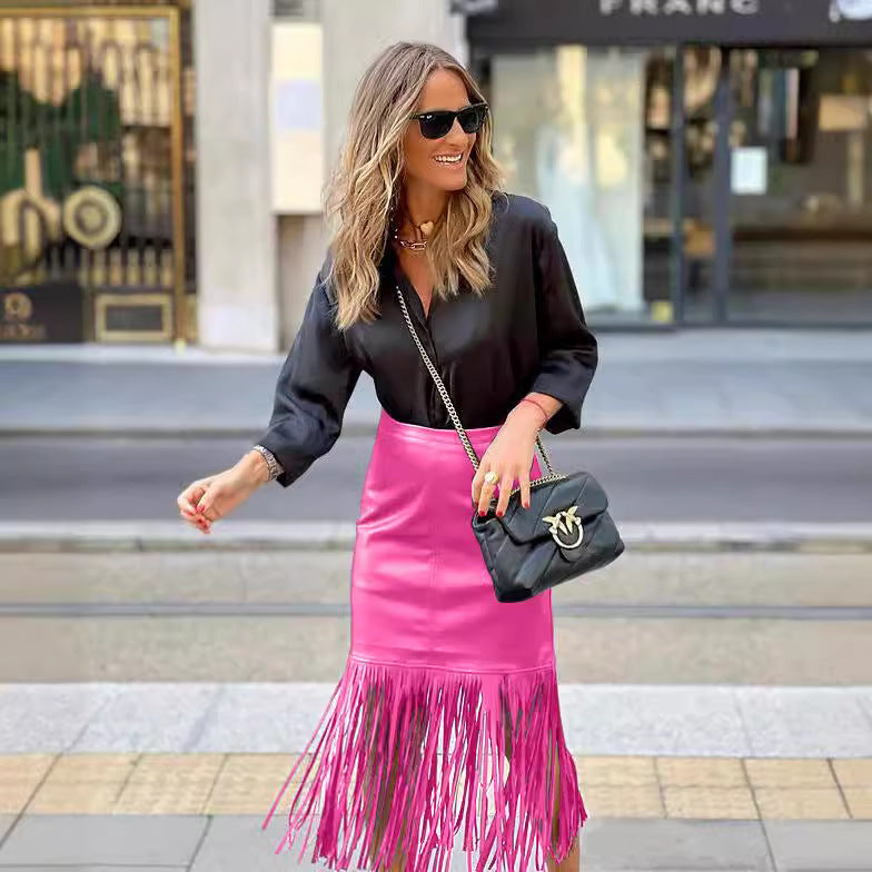 Kvinners fuchsia franje skjørt laget av faux skinn med en tettsittende silhuett og svingende design