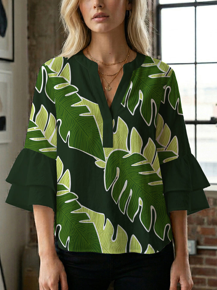 Damebluse med voluminøse volangermer og floral trykk Skjora