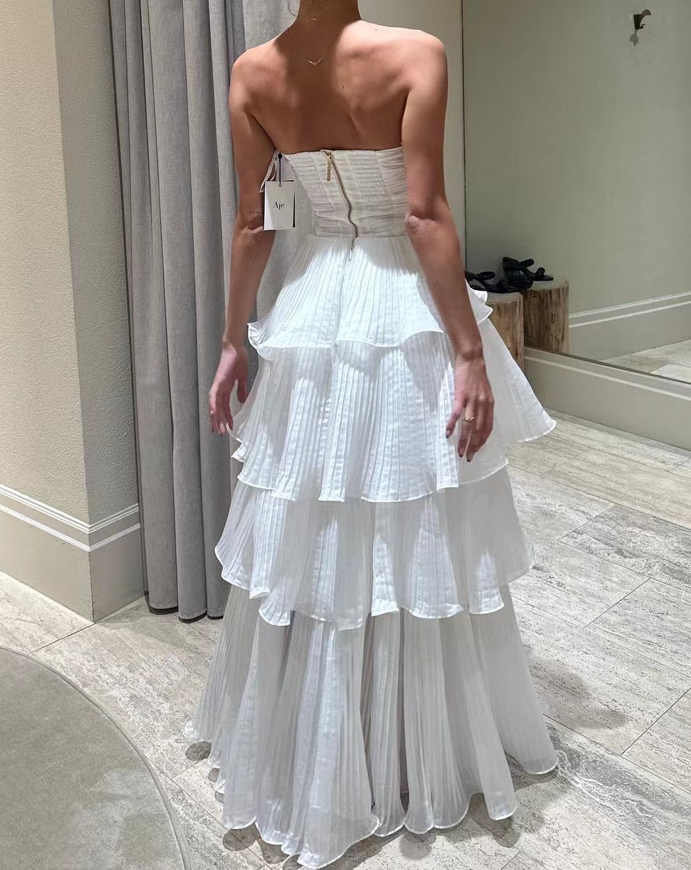 Kvinne kveldsdrakt med voluminøse volangdetaljer og off-the-shoulder design