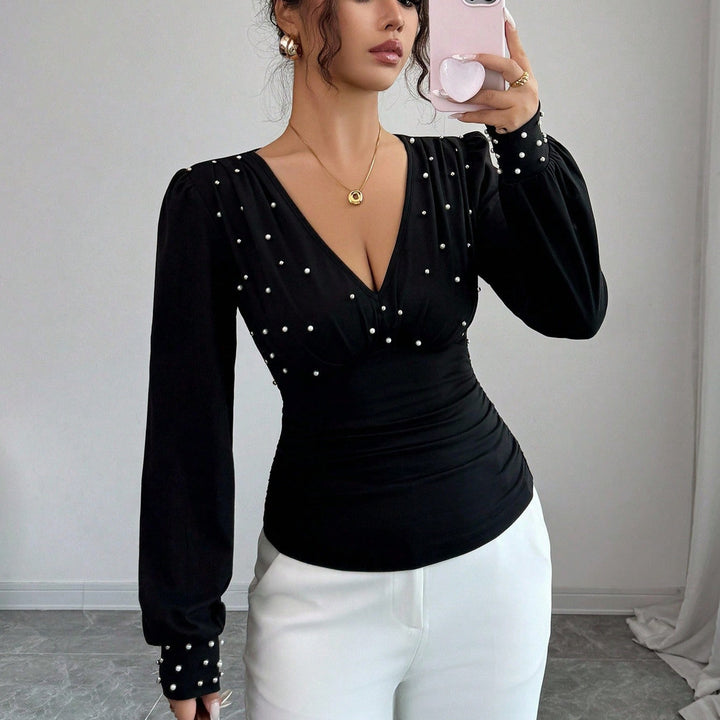 Kvinnes elegant bluse med V-hals og dekorasjon Skjora
