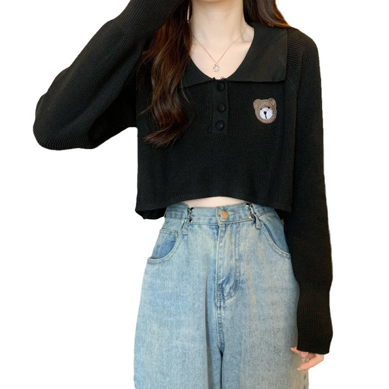 Kvinne cropped genser med en knapp lukking og unicorn emblem